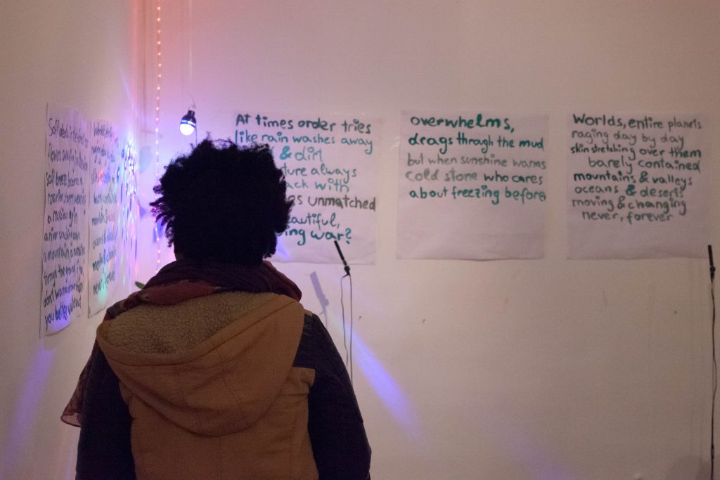 Bild aus der Ausstellung: BLACK EXCELLENCE - eine Person von hinten steht vor einem ausgestellten Text @ Abiona Esther Ojo